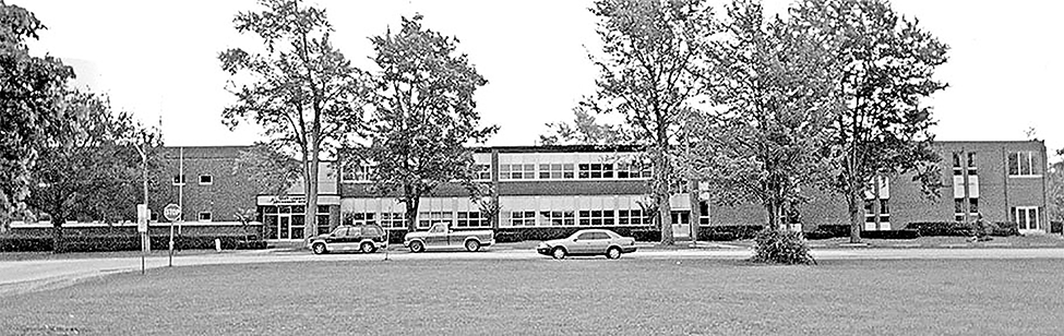 East Lambton Elementary School with a couple cars parked outside.