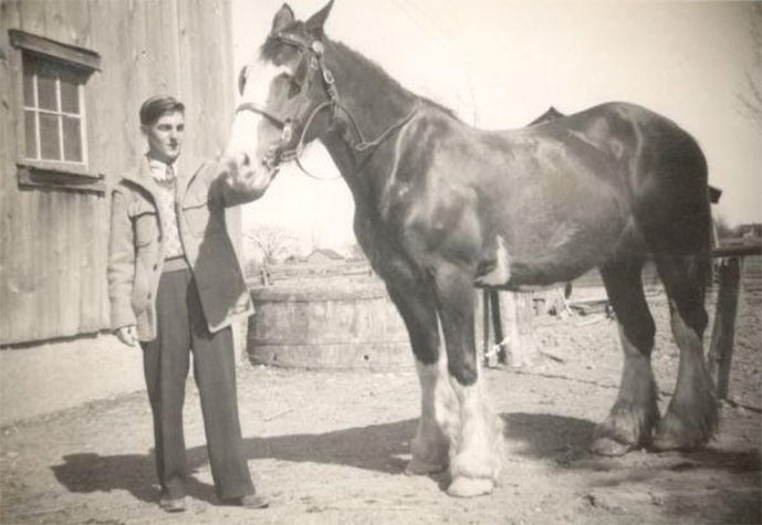 Black and white photo of a man with a horse.