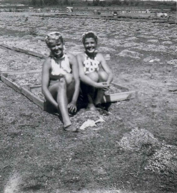 Joan Tovey sitting in a field with Peggy Grunton.