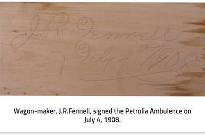 (Signature on wood with caption, "Wagon-maker, J.R. Fennell, signed the Petrolia ambulance on July 4, 1908."), link.
