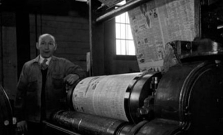 Man standing in front of old press.