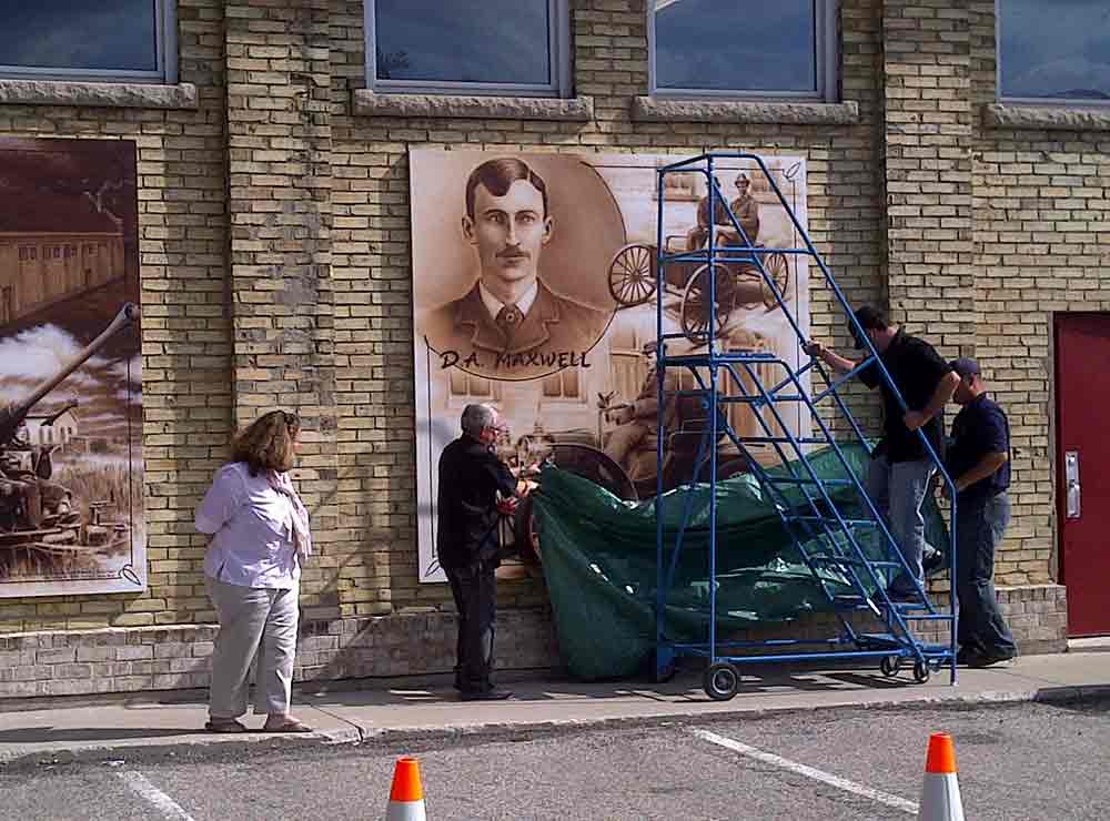 Two people standing by a mural.