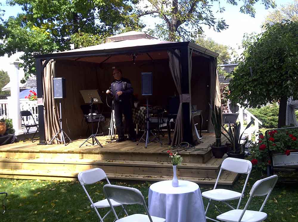 Man standing in an outdoor pavillion.