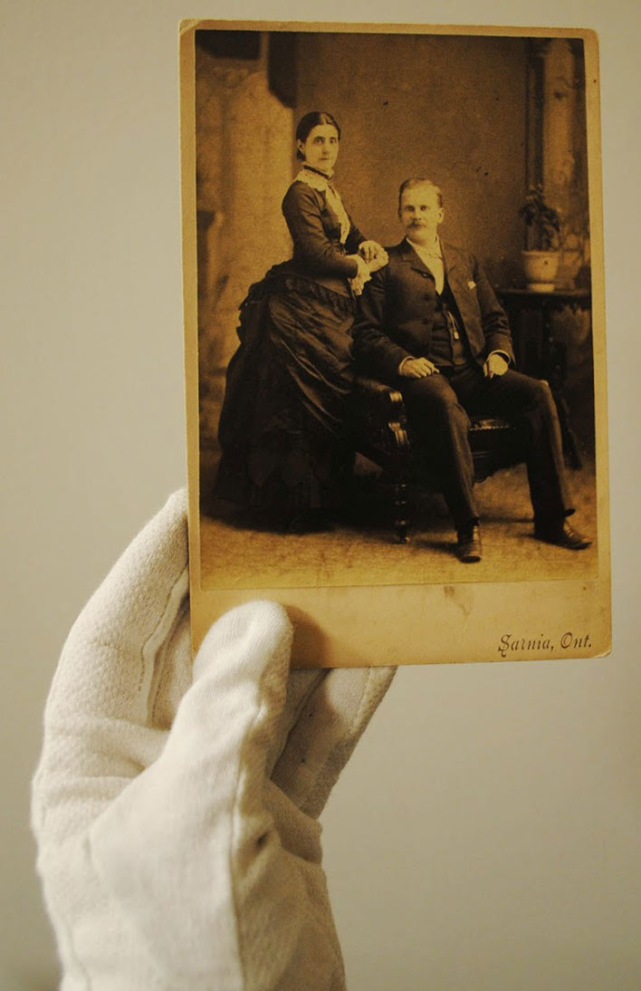 White glove holding photo.