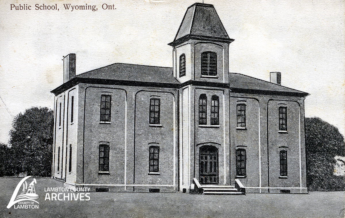 postcard with black and white image of two story school 