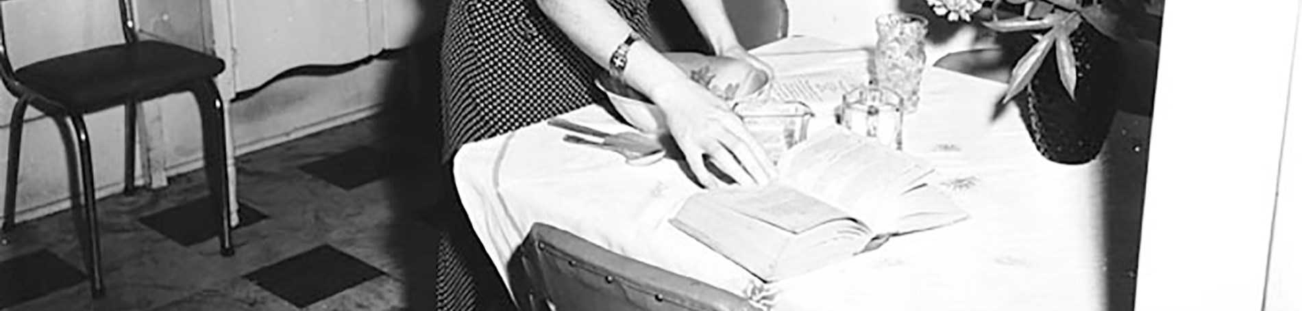 Woman standing next to table with dishes and books.