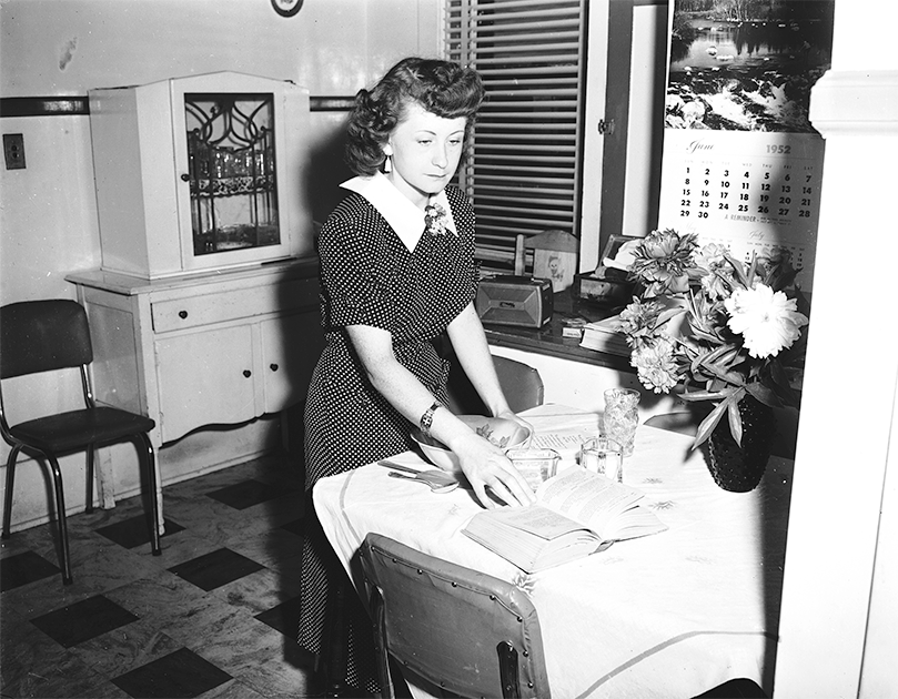 White lady standing in kitchen preparing to make a recipe.