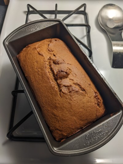 Bread in a loaf pan on a stove.