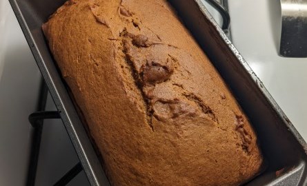 Bread in a bread pan on a stove.