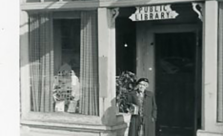 photo of edith rice standing on the steps of the public library.