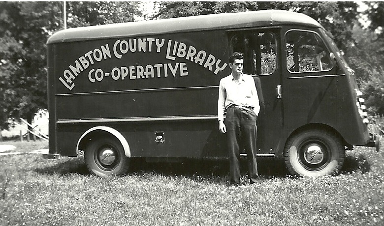 Man standing in front of an antique van.