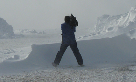 Cameraman standing in the snow.