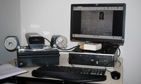 Computer screen and scanner on a table.
