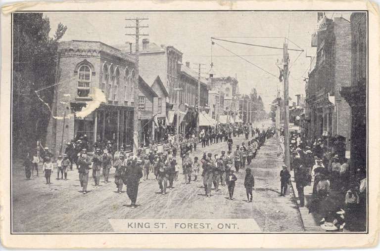 Black and white image of a band playing in a parade.