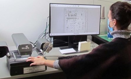 Lady sitting in front of a computer and microfilm reader.