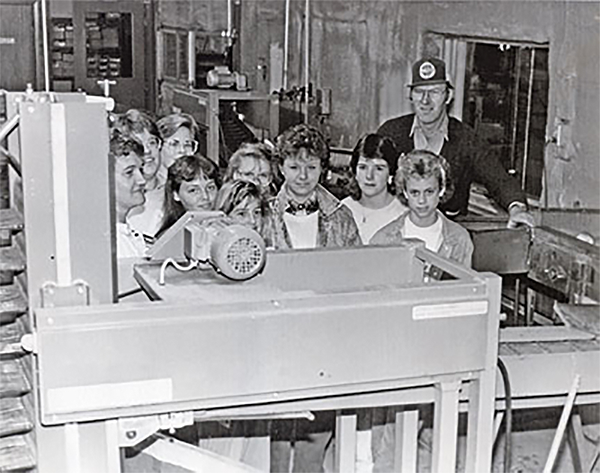 4-H club at Van Diepen’s apple orchard in front of John Van Diepen at the apple grading machine. 