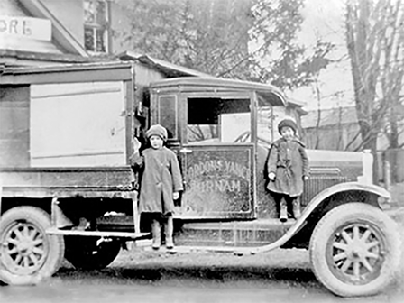 Gordon Vance's first delivery truck with 2 kids standing on the step.