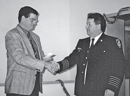 Mayor Mac Parker and Fire Chief Peter Ferwerda shaking hands.