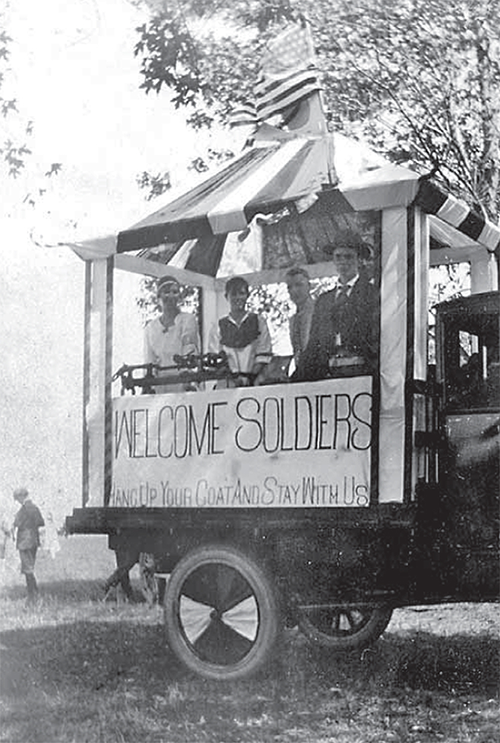 Welcome Home Soldiers stand on top of a trailer.