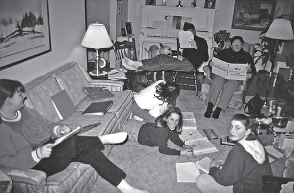 Teen sprawled out around a living room, studying at a 4-H club meeting. 