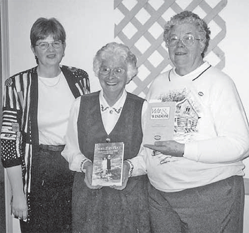 Three women, two holding books.