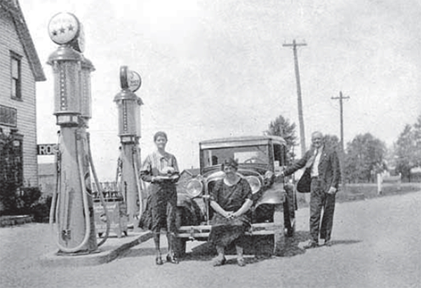 Beside a pump at Waun’s gas station two women pose with a car.