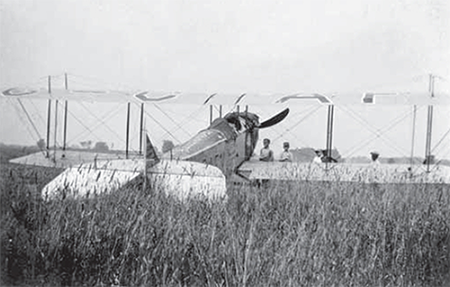 Old Jenny airplane sitting in long grass.