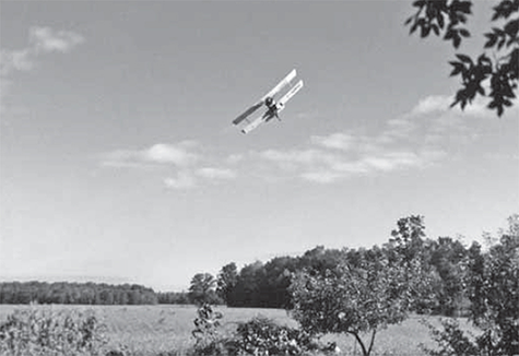 A small plane flying over a field.