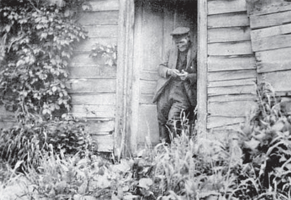 Jimmy Smith leaning in the doorway of a wooden building.