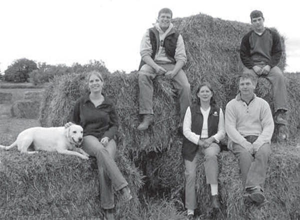 Aarts family sitting on a stack of hay bales.