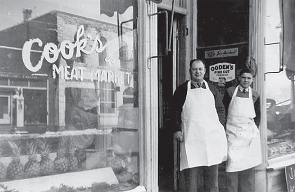 Roy Cook and Glen Edwards stand in front of Cook’s Meat Market.: 