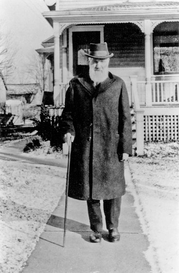 W.B. Laws standing in front of a house.