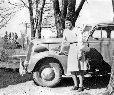 Helen Ross stands in front of a car.