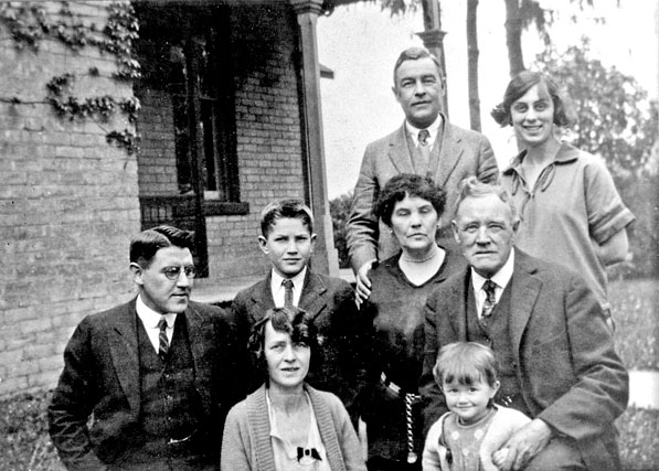 Taylor family beside a brick building.