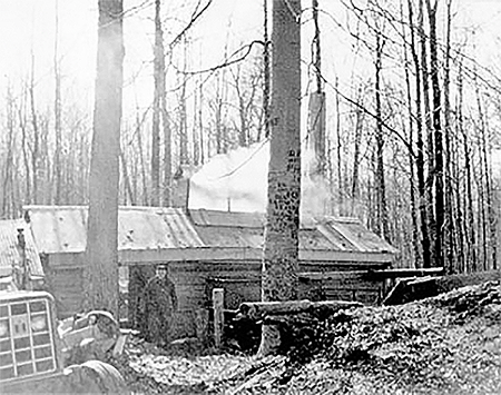 Sugar shanty with Franklin Fuller in doorway. 