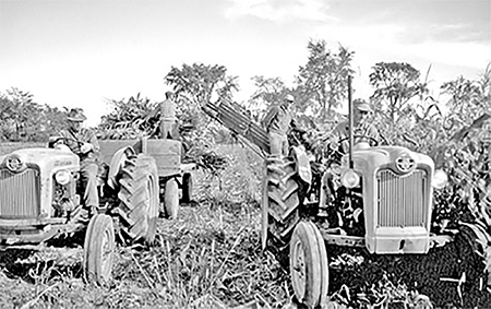 Ron Ellerker with a tractor with a corn binder and a tractor with a wagon.