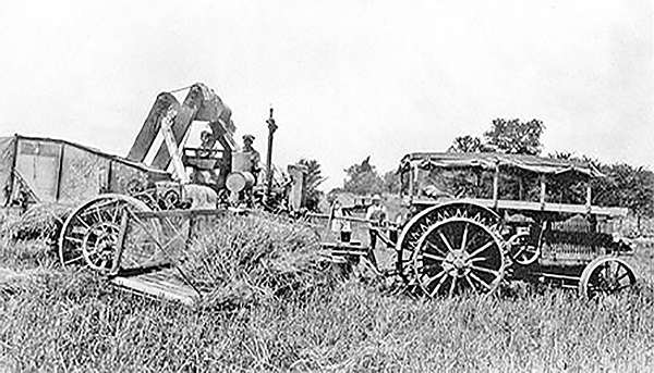 Ernest Albert Edwards combine and covered steel wheel tractor.