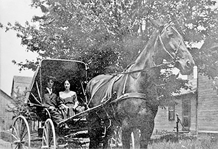 Bill and Annie turner in a horse drawn carriage.