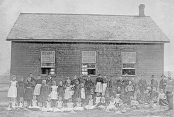 Village School with a large group of children out front.