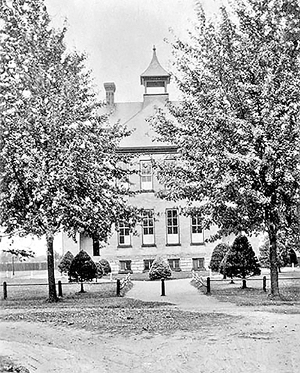 Forest High School hidden partly behind some trees, c. 1920.