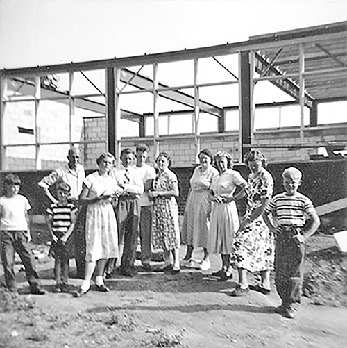 People stand in front of St. Mary’s Roman Catholic School being built.