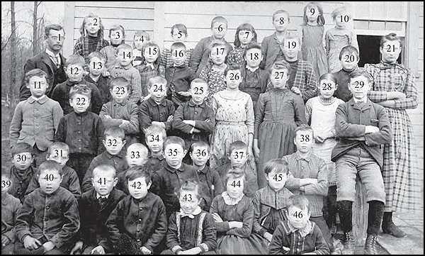 Children standing outside of a school, SS#15. They are all numbered for identification.