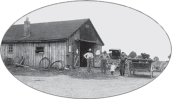 Blacksmith shop with two men and a child standing out front.