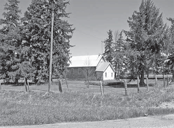 SS#16, A building with a large grass yard, behind an old fence.