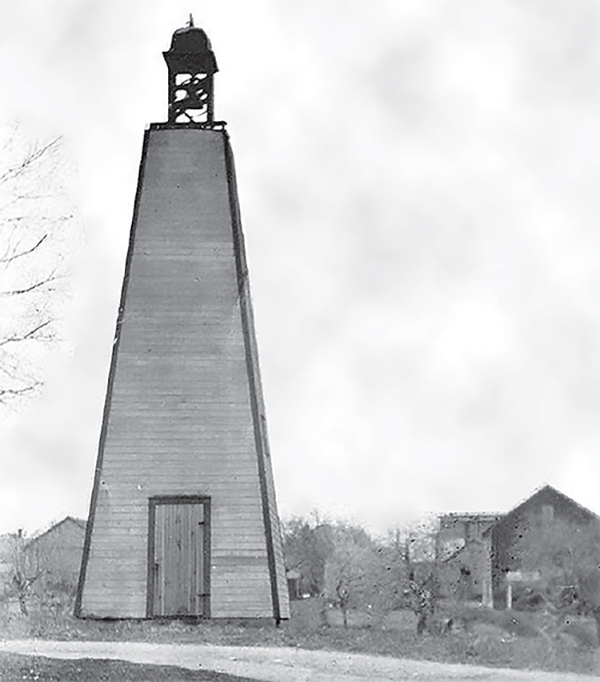 A wooden belfry with a metal bell.