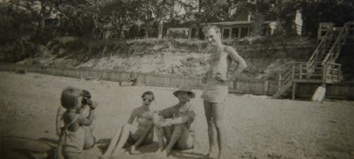 Black and white image of a family on a beach.