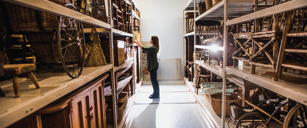 Museum curator standing in an aisle of the collections storage at Lambton Heritage Museum