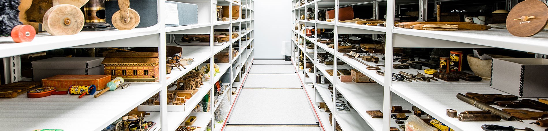 Woman standing in museum's collection on shelf. 