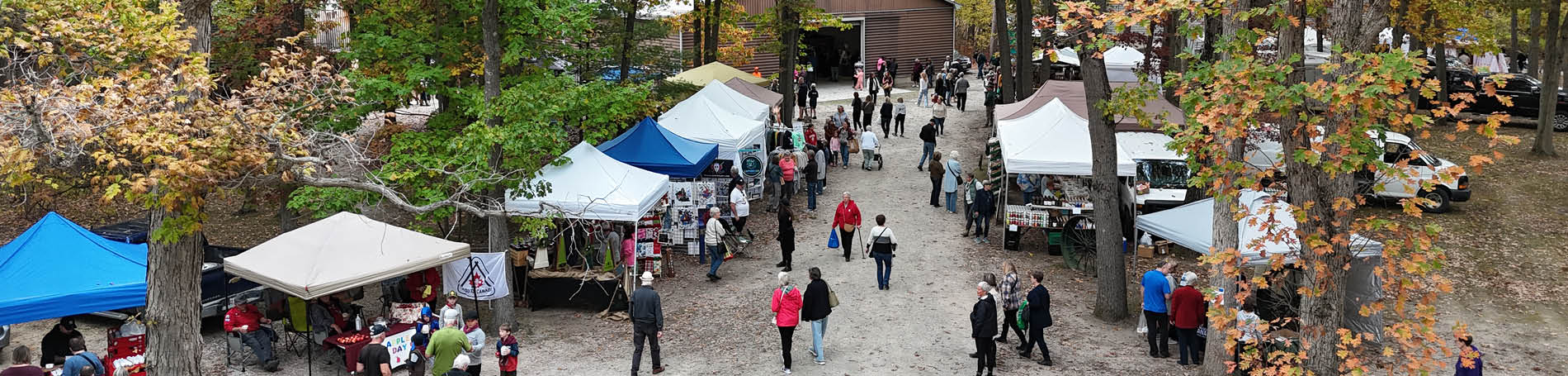 Visitors and vendor tents amongst the autumn oak savanna backdrop.