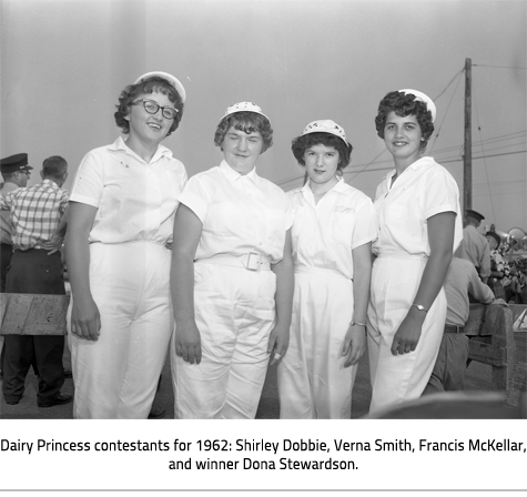 (Four women dressed in white caps and jumpsuits. Image Caption:"Dairy Princess contestants for 1962: Shirley Dobbie, Verna Smith, Francis McKellar, and winner Dona Stewardson."), link.